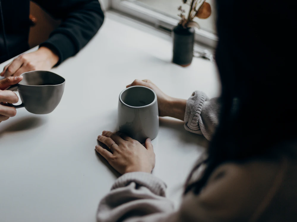 Échange direct autour d'un café entre la webdesigner et sa cliente